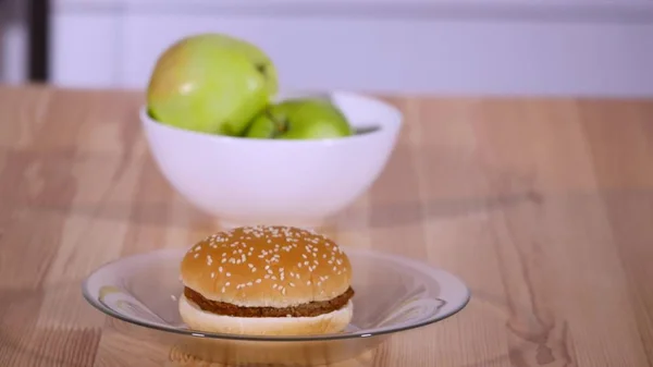Fermer les pommes et le hamburger dans une assiette — Photo