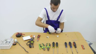 Bir elektrikçi soket için fiş onarır