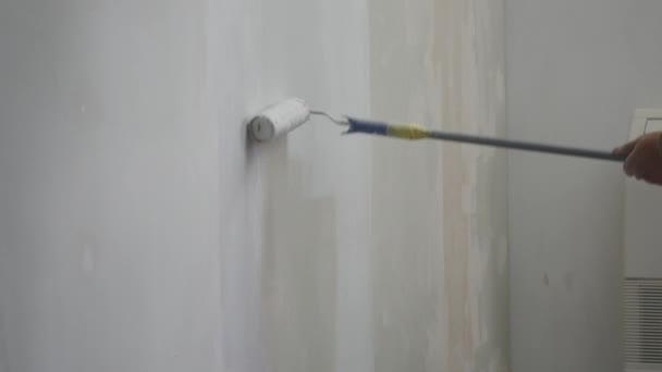 Pintor homem no trabalho, com rolo pintando a parede, pintor casa conceito — Vídeo de Stock