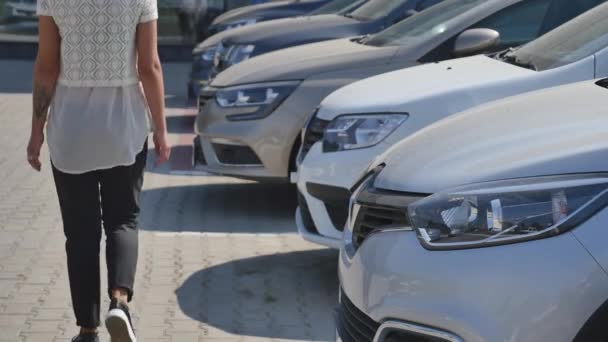 Woman choosing car for buying in dealership really desiring — Stock Video