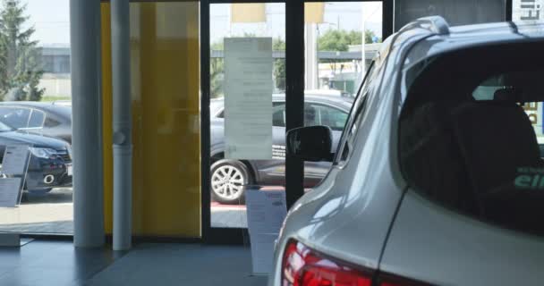 Young woman coming to the car dealership — Stock Video