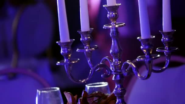 Kerzenständer mit Kerzen brennt im dunklen Restaurant, Wachskerzen im Kerzenständer, dekorative Kerzen brennen, Dekoration des Festsaals, geringe Schärfentiefe — Stockvideo