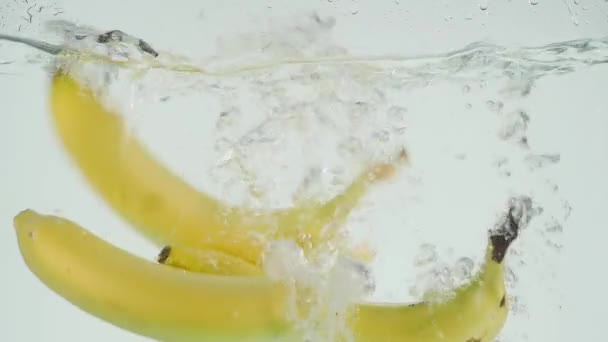 Bananen van Slo-beweging vallen in water — Stockvideo