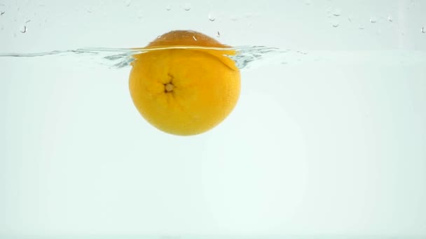 Slo-motion whole orange falling into water — Stock Video