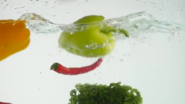 Legumes frescos salpicando na água no fundo preto — Vídeo de Stock