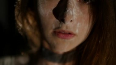 Güzel bir genç kız bir stüdyoda siyah bir arka plan önünde poz veriyor. O büyük poz olarak kar yağışı sanki gibi beyaz un miktarda vücudunda düşmek