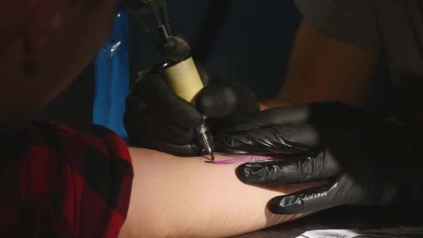 Primer plano de tatooer en guantes negros haciendo tatoo — Vídeos de Stock