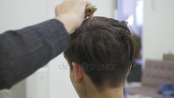 Молодая женщина в парикмахерской высушивает волосы — стоковое видео