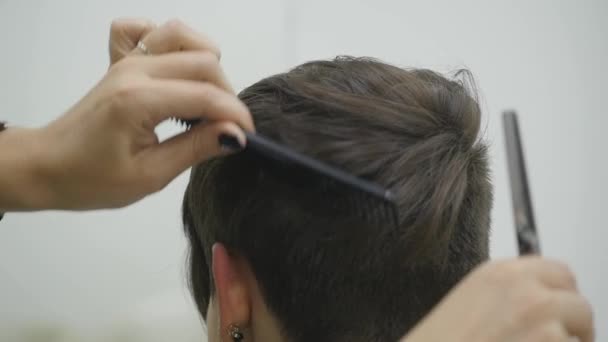 La peluquera de las mujeres hace peinar su cabello en el pelo corto — Vídeo de stock