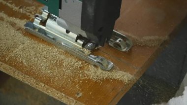 Bir ahşap tahta kesme marangoz close-up. Bir adam bir el daire testere ile ahşap bir parça keser