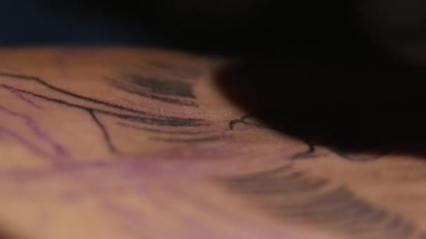 Tatoueur colorant tatoo avec une machine à tatoo. gros plan 