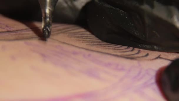 Tatoueur colorant tatoo avec une machine à tatoo. gros plan 