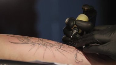Dövme sanatçısı yakından boya ile Başlarken dövme yapma süreci gösterir. steril eldiven. Profesyonel bir salonda dövme dolgu devre dövme ustası