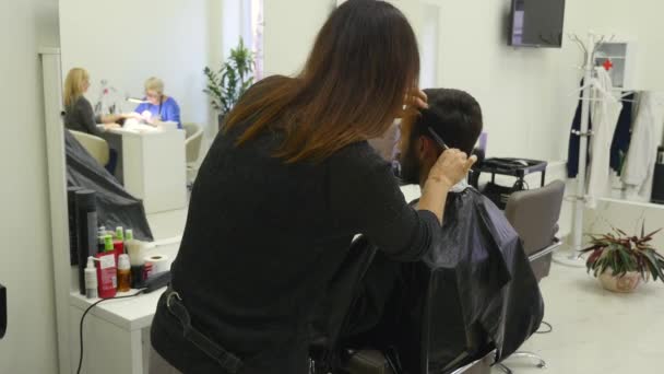 Junger Mann im Friseursalon. Friseurin und ihr Kunde. — Stockvideo