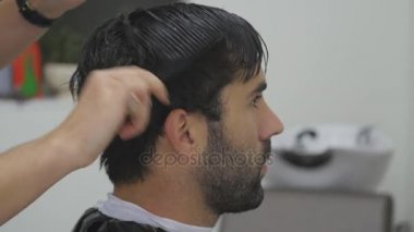 Bir kuaför salonu içinde çalışan bir genç ve profesyonel saç stilisti bir atomizer sudan şık bir saç modeli yapmak için ziyaret edenler saçının sprinkles