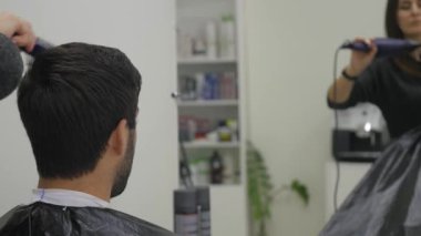 Profesyonel Kuaför Güzellik Salonu saç kurutma. Erkek genç müşteri ve kadın Kuaför. yakın çekim