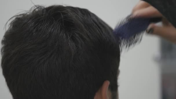 Cabeleireiro profissional secando o cabelo no salão de beleza. Jovem cliente e barbeiro. de perto — Vídeo de Stock