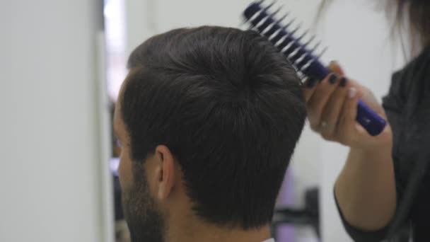 Peluquería profesional secando el cabello en el salón de belleza. Joven cliente masculino y peluquero femenino. de cerca — Vídeos de Stock