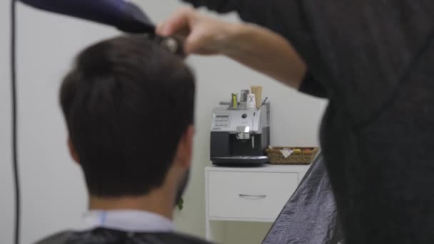Cabeleireiro profissional secando o cabelo no salão de beleza. Jovem cliente e barbeiro. de perto — Vídeo de Stock