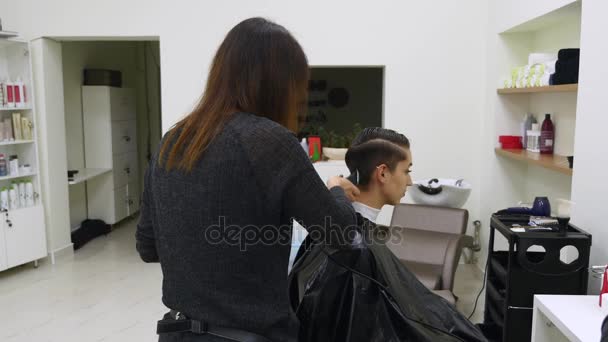 Młoda kobieta cięcia włosy u fryzjera. Fryzjerka tnie włosy do młodej dziewczyny z Profesjonalne nożyczki — Wideo stockowe