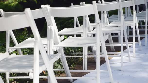 Dolly of rows of chairs at a wedding ceremony from the aisle and from the back — Stock Video
