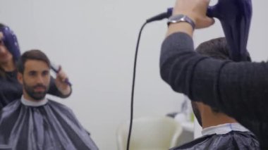 Profesyonel Kuaför Güzellik Salonu saç kurutma. Erkek genç müşteri ve kadın Kuaför. yakın çekim