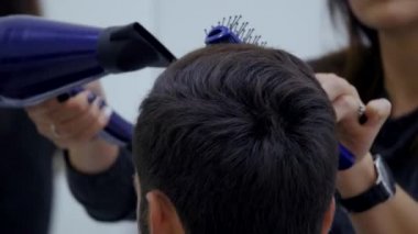 Profesyonel Kuaför Güzellik Salonu saç kurutma. Erkek genç müşteri ve kadın Kuaför. yakın çekim
