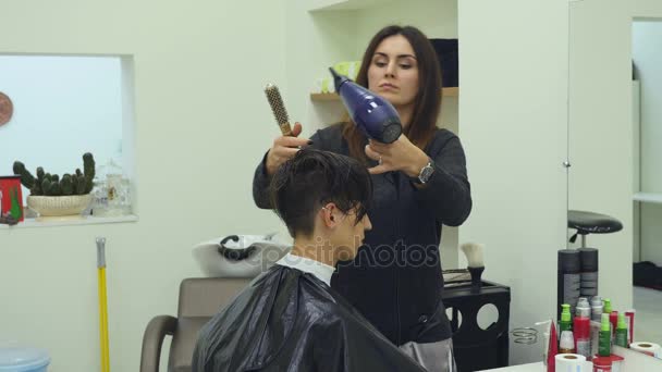 Kadeřnice, sušení a kartáčování vlasů Žena v kadeřnictví — Stock video