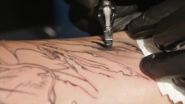Художник татуювання робить татуювання в студії, татуювання на тілі. крупним планом — стокове відео