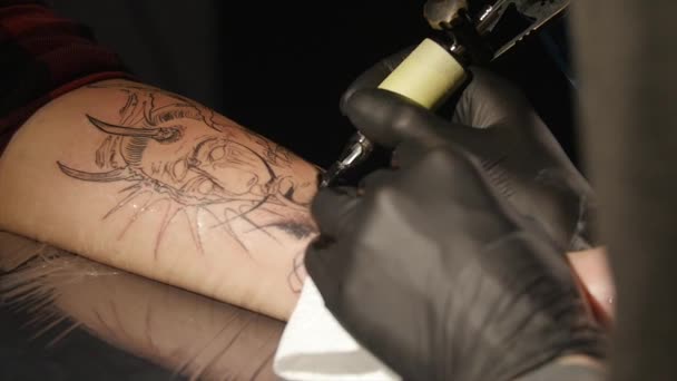Художник татуювання робить татуювання в студії, татуювання на тілі. крупним планом . — стокове відео