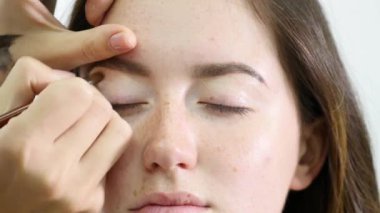 bir genç kızın kaşları koyu profesyonel boya makyaj sanatçısı boyalar