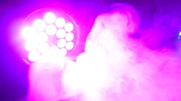 Fumaça grossa fazendo redemoinhos em holofotes vigas. Ambiente abstrato feliz colorido para fundo — Fotografia de Stock