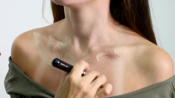 Maquiagem artista aplicando base tonal líquido no pescoço meninas em branco compõem quarto. Conceito de beleza e moda — Vídeo de Stock