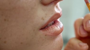 Portre profesyonel makyöz güzellik moda sektöründe çalışan modelleri dudaklarında ruj uygulama görünümünü. Özel fırça kullanarak bir sanatçı el closeup görünümü. ağır çekim