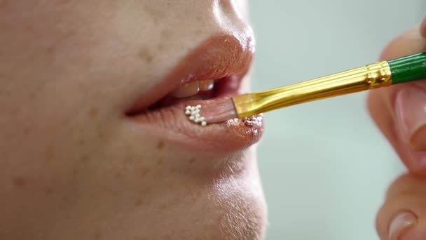 Makeup artist sætter konfetti på læberne. konfetti på læberne, smuk fyldes op og lyse farvelægger af læber – Stock-video