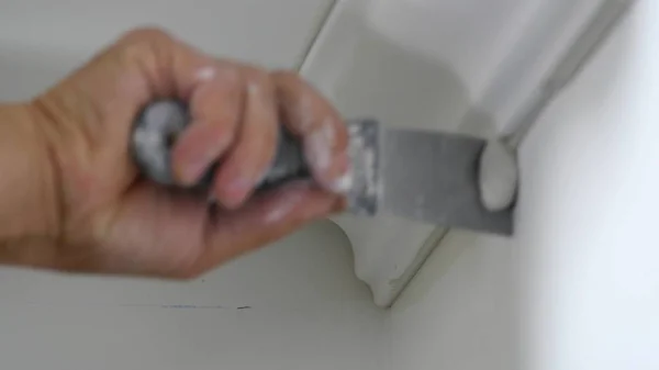 Worker fixes the plinth to the ceiling close up — Stock Photo, Image