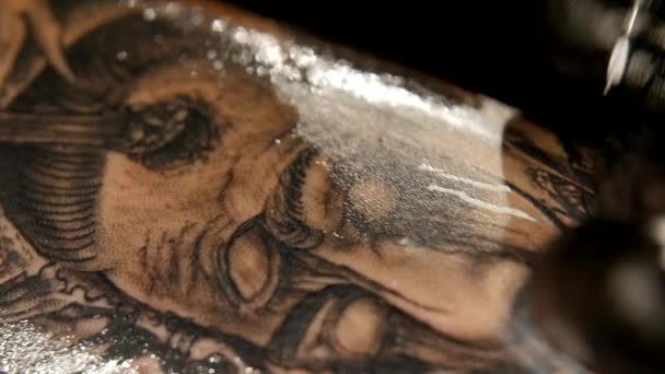 Татуировщик делает татуировку в студии, делает татуировку на теле. close up — стоковое видео
