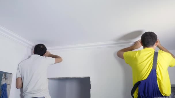 Två arbetare fixar sockeln till taket — Stockvideo