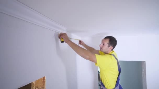 Arbetaren fixar sockeln till taket — Stockvideo