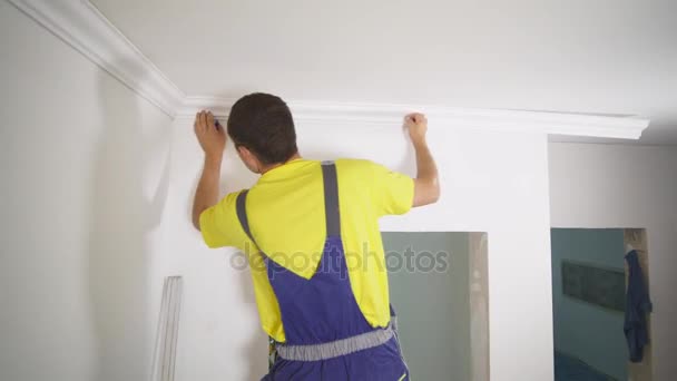 Il lavoratore fissa lo zoccolo al soffitto — Video Stock