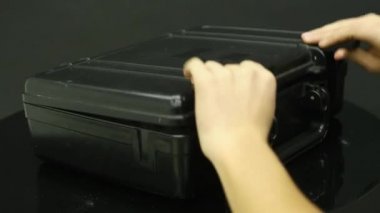 Bir adam bir siyah metal çanta para ile açar.