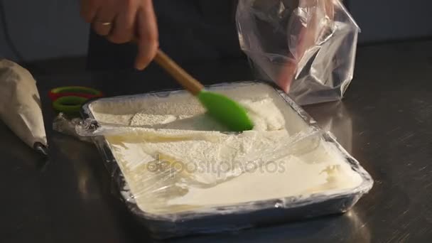 Die Hand eines Mannes legt eine Creme in eine Süßwarenspritze — Stockvideo