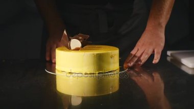 Pasta ayrıntıları. Çikolata ve kraker. Taze pişmiş kek. Pastacı pasta döner ve süsleyin. Sarı kek çikolatalı krema, çikolata ve kraker. Pudra süslemeleri bir
