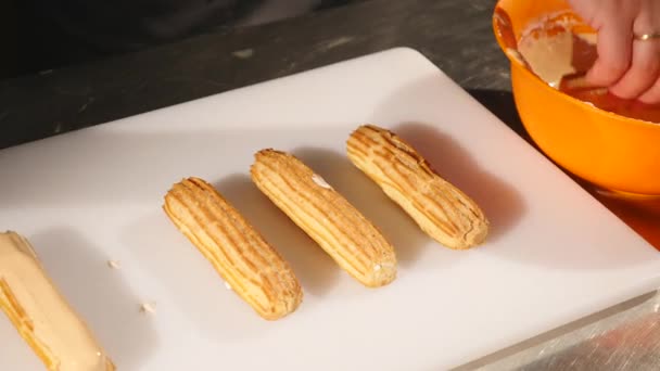 Mani di pasticceria sapientemente fare un capolavoro culinario in negozio di caramelle o pasticceria. Produzione, concetto di industria alimentare — Video Stock