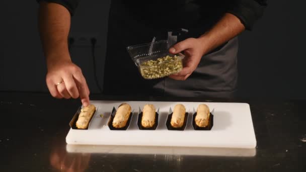 Las manos de un pastelero hábilmente hacen una obra maestra culinaria en una tienda de dulces o pastelería. Producción, concepto de industria alimentaria — Vídeos de Stock