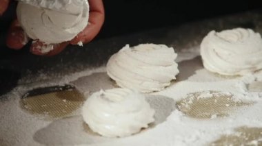 el ile krema şeker elek kullanarak bir zephyr yağmurlama mans. Pudra toz şeker marshmallow üzerinde sprinkles.