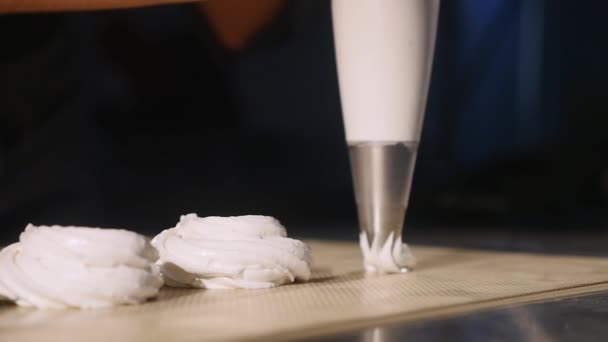 Кондитер из шприца, чтобы протолкнуть массу в кастрюлю для зефира. close up — стоковое видео