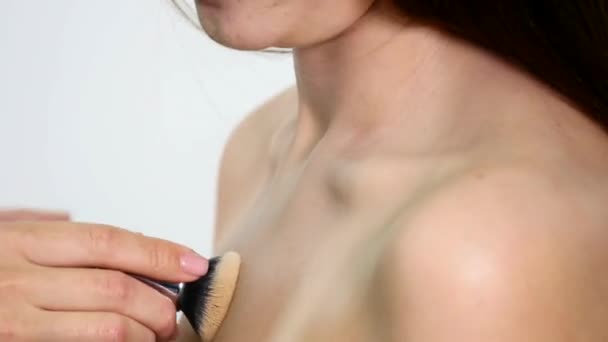 Artista de maquillaje aplicando base tonal líquida en el cuello de las niñas en la habitación de maquillaje blanco. Concepto de belleza y moda — Vídeo de stock