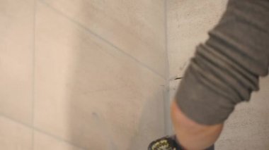 El dikişleri bej fayans duvar koyarak mans. Yakın çekim. ağır çekim