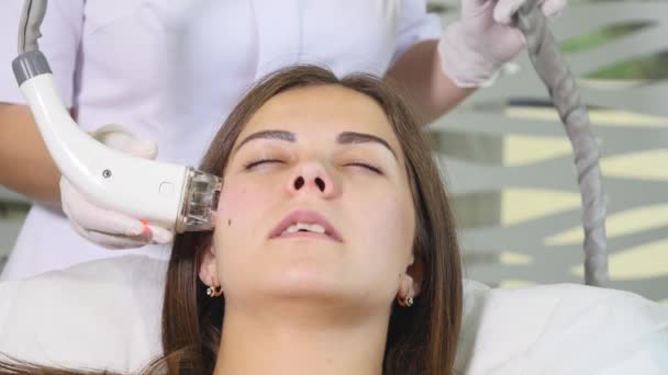 Uma mulher a levantar-se num salão de beleza. Mulher a ter um tratamento facial estimulante. Cara de pele. Tratamento da pele — Vídeo de Stock